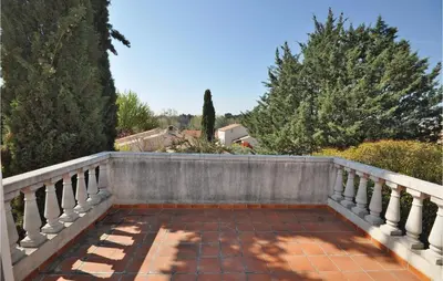 a balcony with a stone fence and trees at Nice Home In Saint Cannat With Wifi in Saint-Cannat