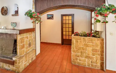 a living room with a brick fireplace and flowers at Nice Home In Saint Cannat With Wifi in Saint-Cannat