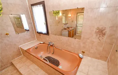 a bathroom with an orange tub and a mirror at Nice Home In Saint Cannat With Wifi in Saint-Cannat
