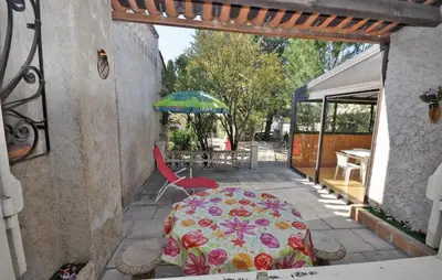 a patio with a table and an umbrella and a chair at Nice Home In Saint Cannat With Wifi in Saint-Cannat