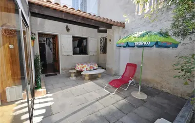 a patio with a red chair and an umbrella at Nice Home In Saint Cannat With Wifi in Saint-Cannat