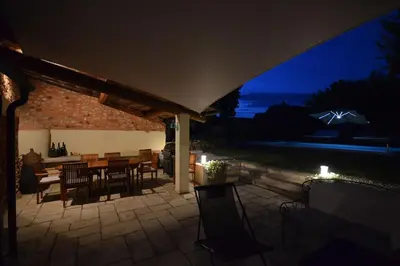 a patio with a table and chairs at night at La maison d'Anthonie, Roussillon in Roussillon