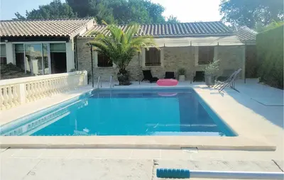 a swimming pool in front of a house at La Maoure in Robion en Luberon