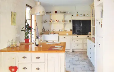 a kitchen with white cabinets and a counter top at La Maoure in Robion en Luberon