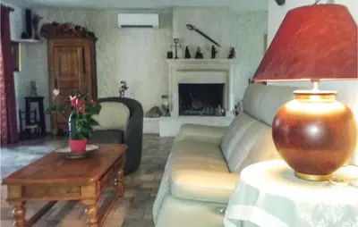 a living room with a couch and a table with a lamp at La Maoure in Robion en Luberon