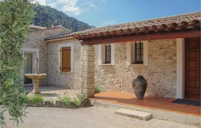 a stone house with a vase in front of it at La Maoure in Robion en Luberon