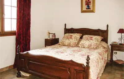 a bedroom with a wooden bed with pillows on it at La Maoure in Robion en Luberon