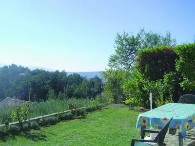 a table and chairs in a garden with a view at Gîte Le Val des Fées classés deux étoiles in Roussillon