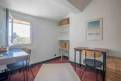a room with chairs and a table and a window at Petit Cocon avec Vue Dernier Etage - Mazarin 1833 in Aix-en-Provence