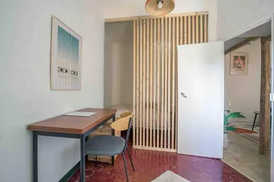 a room with a desk and a table with a chair at Petit Cocon avec Vue Dernier Etage - Mazarin 1833 in Aix-en-Provence