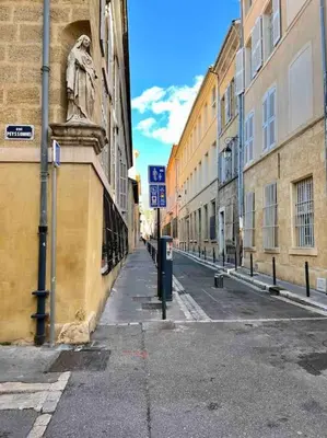 an empty city street with buildings and a parking meter at Petit Cocon avec Vue Dernier Etage - Mazarin 1833 in Aix-en-Provence