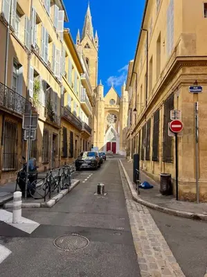 an empty city street with a church and cars parked at Petit Cocon avec Vue Dernier Etage - Mazarin 1833 in Aix-en-Provence