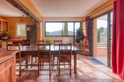 a dining room with a wooden table and chairs at La Maison du Chapelier in Fontaine-de-Vaucluse