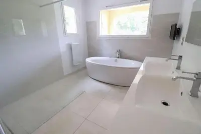 a white bathroom with a tub and a sink at Mas Libertino - Villa avec piscine & jacuzzi in Pernes-les-Fontaines