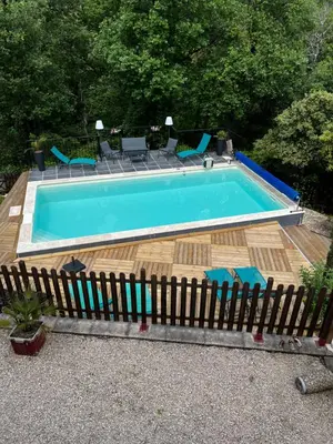 a swimming pool with a wooden fence around it at La Bastide de Mauragne - Gîte Les Pivoines in Apt