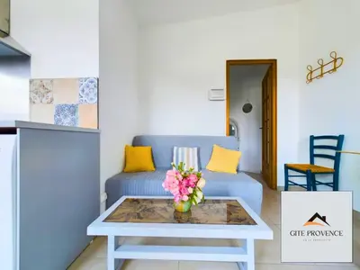 a living room with a blue couch and a table at Gîte de la Draillette in Noves