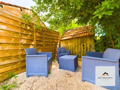 three blue chairs sitting next to a wooden fence at Gîte de la Draillette in Noves