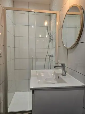 a white bathroom with a sink and a shower at La villa Li Grihet in Beaumont-de-Pertuis