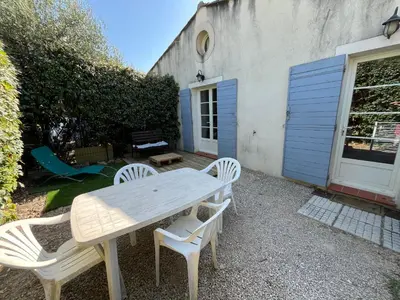 a white table and chairs in front of a house at LES VIEUX CABASSOLS VENELLES in Venelles