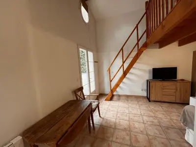a living room with a wooden bench and a television at LES VIEUX CABASSOLS VENELLES in Venelles