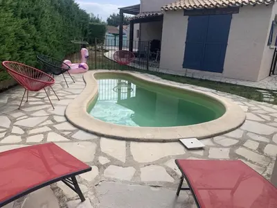 a small swimming pool with two chairs and a table at Chez Jenn- Jolie maison climatisée avec piscine in Monteux