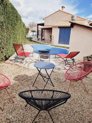 a group of chairs and a table in front of a pool at Chez Jenn- Jolie maison climatisée avec piscine in Monteux