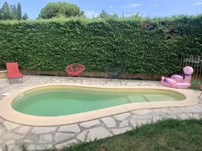 a small pool with chairs and a pink flamingo in a yard at Chez Jenn- Jolie maison climatisée avec piscine in Monteux