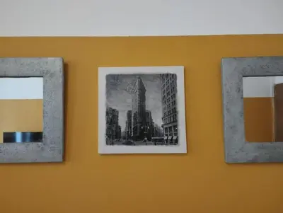 two framed pictures of a city on a wall at Appartement en plein centre. in Carpentras
