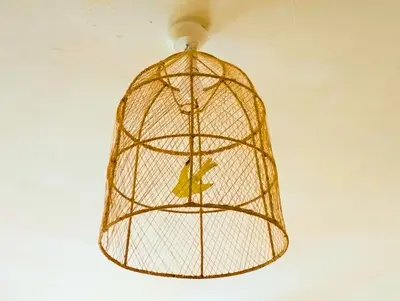a bird cage hanging from a ceiling at Appartement en plein centre. in Carpentras