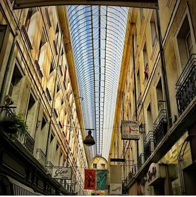 a building with a glass ceiling in a street at Appartement en plein centre. in Carpentras