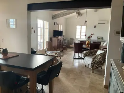 a living room with a table and a dining room at Lou Jasset in Cabrières-dʼAigues