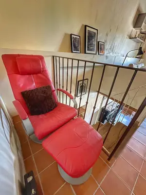 a red chair and a red ottoman in a room at La Terrasse - Entire townhouse in hilltop village in Saint-Martin-de-Castillon