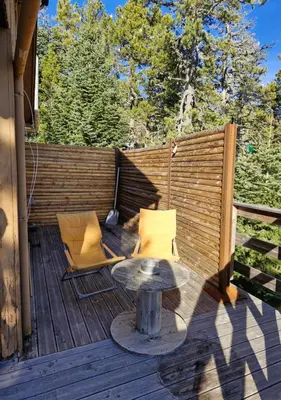 a patio with a table and chairs on a deck at Chalet du Mont Ventoux - Rendez-vous en Provence in Bédoin