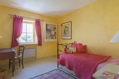 a bedroom with a bed with a teddy bear on it at Mas des Papillons Gordes in Gordes