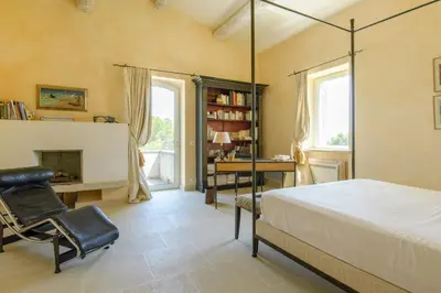 a bedroom with a bed and a desk and a chair at Mas des Papillons Gordes in Gordes