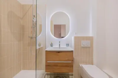 a bathroom with a sink and a shower with a mirror at Appartement de Charme in Aix-en-Provence
