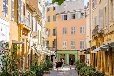 a group of people walking down a street with buildings at Appartement de Charme in Aix-en-Provence