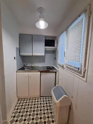 a small kitchen with white cabinets and a checkered floor at Studio, Aix centre historique in Aix-en-Provence