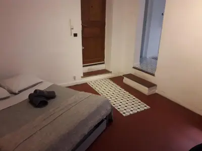 a bedroom with a bed and a window and a door at Studio, Aix centre historique in Aix-en-Provence