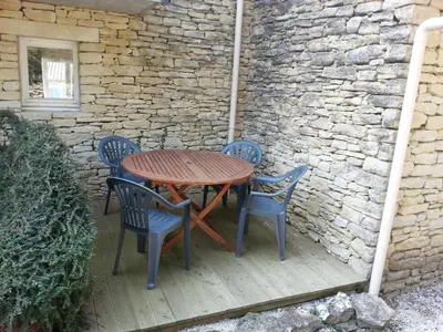 a wooden table and chairs on a patio at Gordes Le Bastidon in Gordes