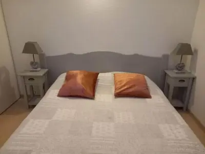 a bedroom with a bed with two tables and two pillows at Maison de vacances Aubignan in Aubignan