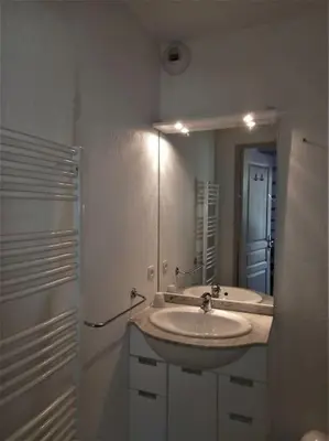 a white bathroom with a sink and a mirror at Maison de vacances Aubignan in Aubignan