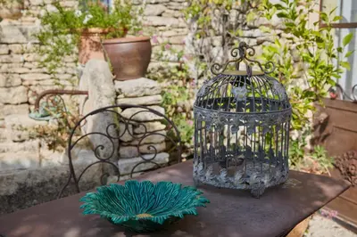 a bird cage sitting on top of a table at Mas de la Beaume in Gordes