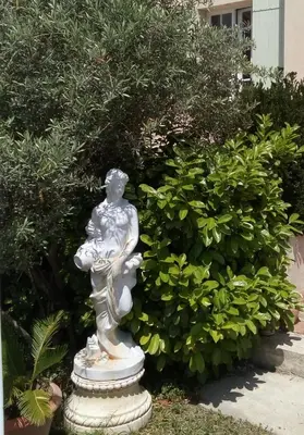 a statue of a woman sitting in a garden at Hote-Aix-Centre-garage-piscine in Aix-en-Provence