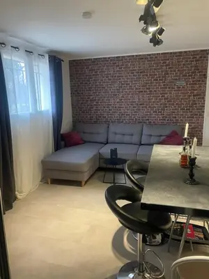 a living room with a couch and a brick wall at Appartement in Caumont-sur-Durance