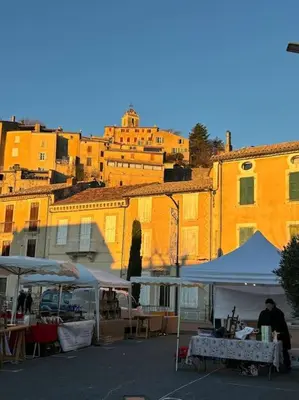 an outdoor market with tents in front of buildings at plein coeur de BANON in Banon