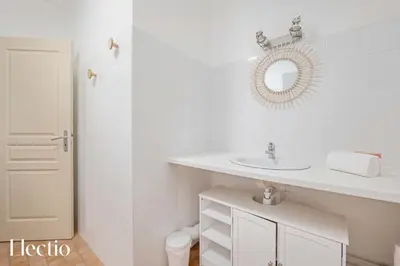 a white bathroom with a sink and a mirror at Maison Alena Lourmarin Main Square in Lourmarin