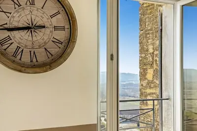a large clock on a wall next to a window at Les Terrasses du Château I Electio in Lauris