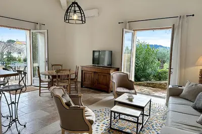 a living room with a couch and a tv at Appartement I Bastide La Gravière I Electio in Lourmarin