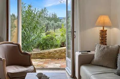 a living room with a couch and a sliding glass door at Appartement I Bastide La Gravière I Electio in Lourmarin